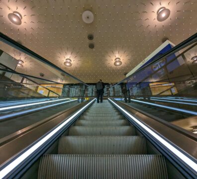 Low angle view of escalators in a modern station with unique ceiling design.